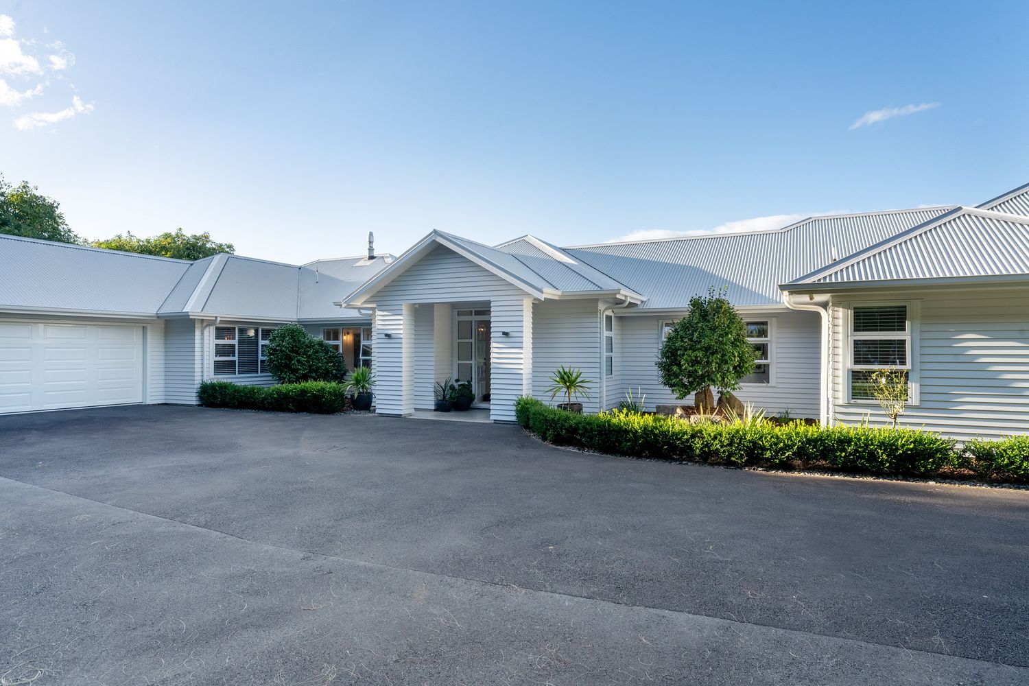 Modern white residential buildings with paved driveways showcasing contemporary suburban housing development.