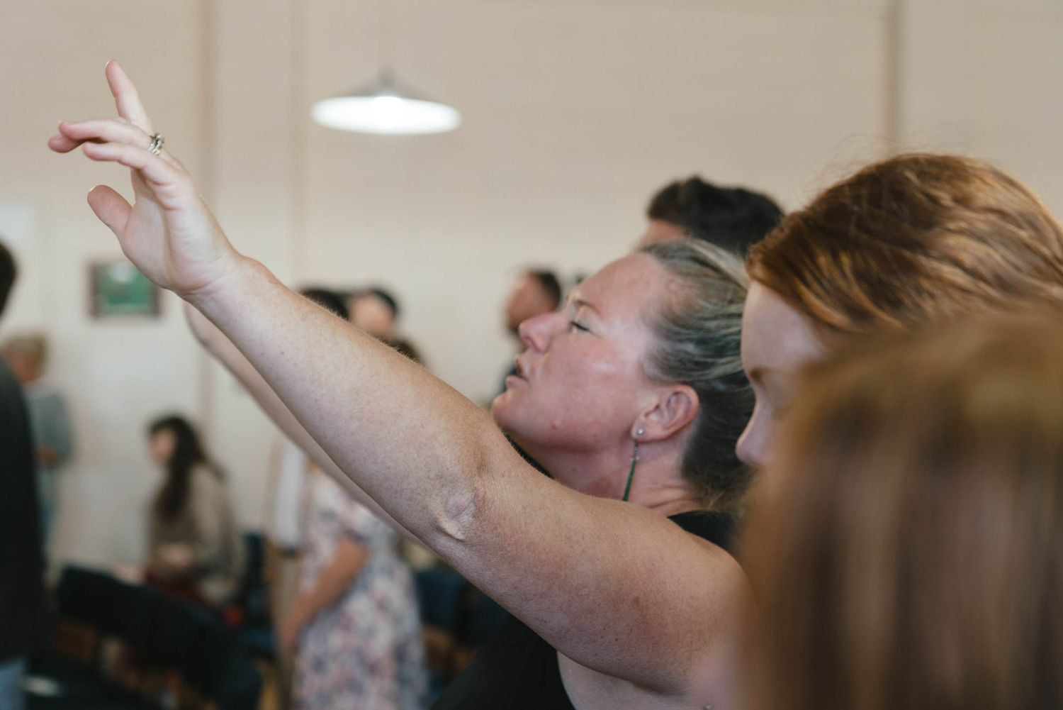 A person raising their hands during a worship service.