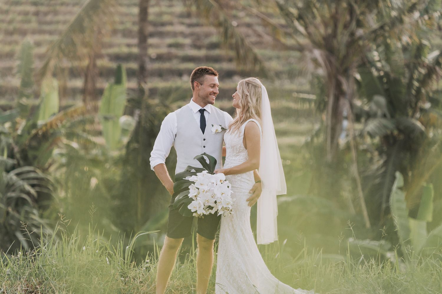 Elegant wedding photography session in a terraced garden with tropical landscaping.