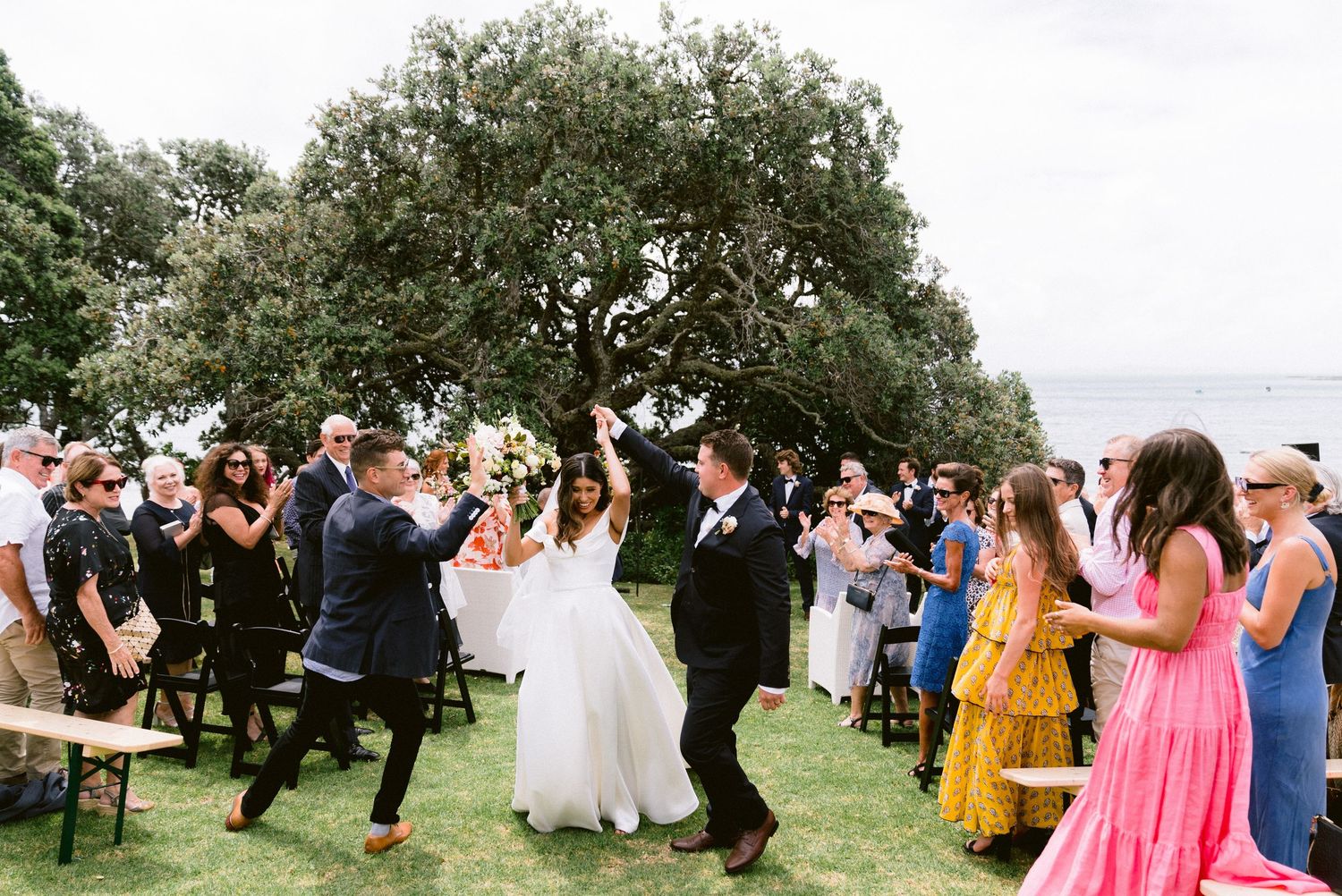 Wedding guests celebrate during an outdoor reception with dancing and festivities.