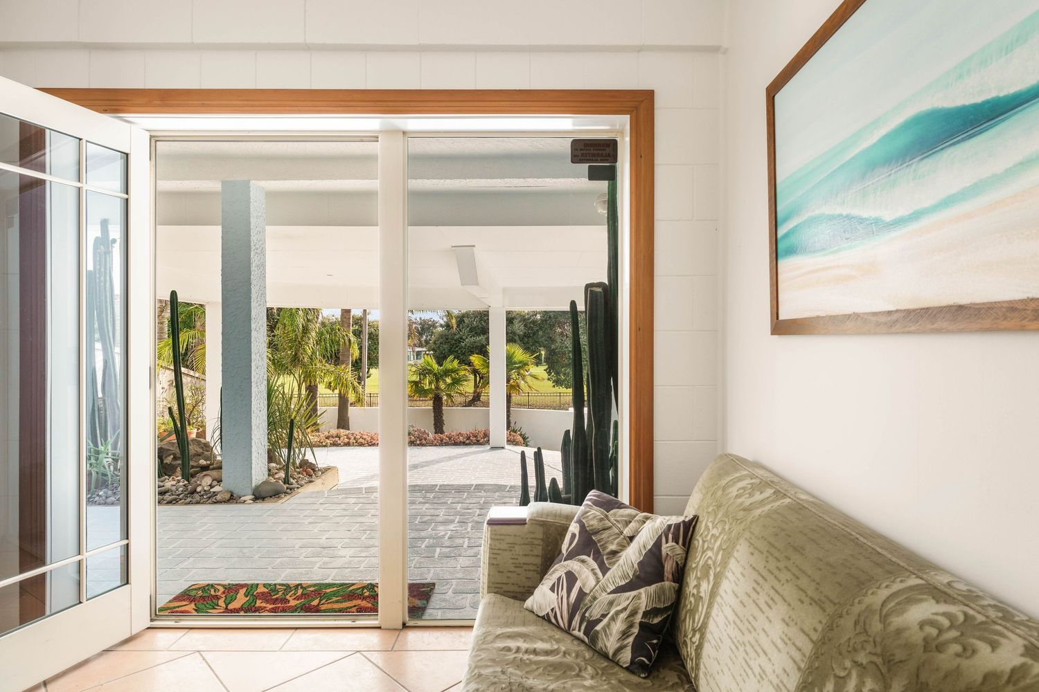 Contemporary living space with coastal artwork and turquoise accents creating a beachy atmosphere.