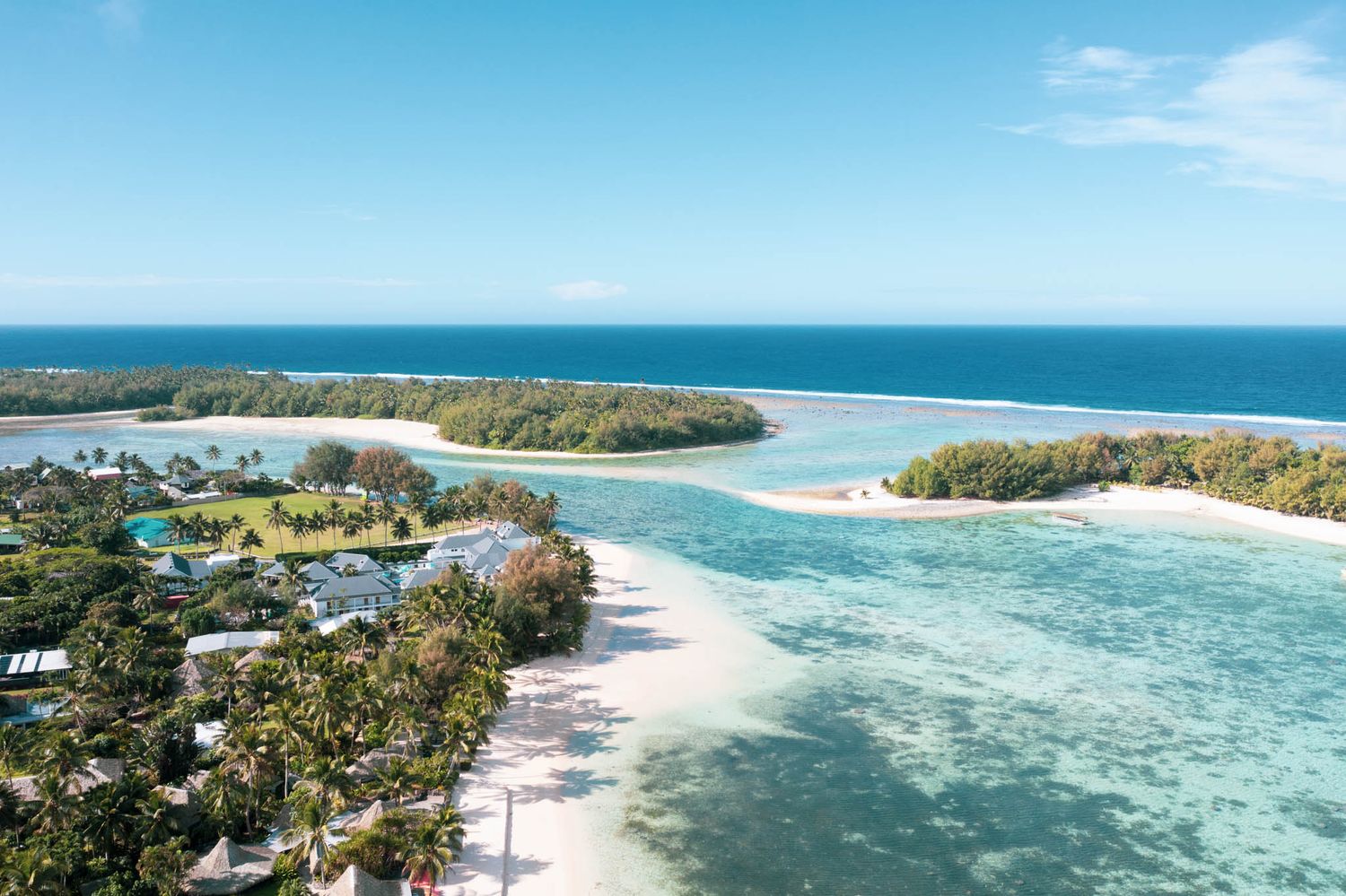 Aerial view of tropical islands with turquoise waters, white sandy beaches and lush vegetation in a coral lagoon.