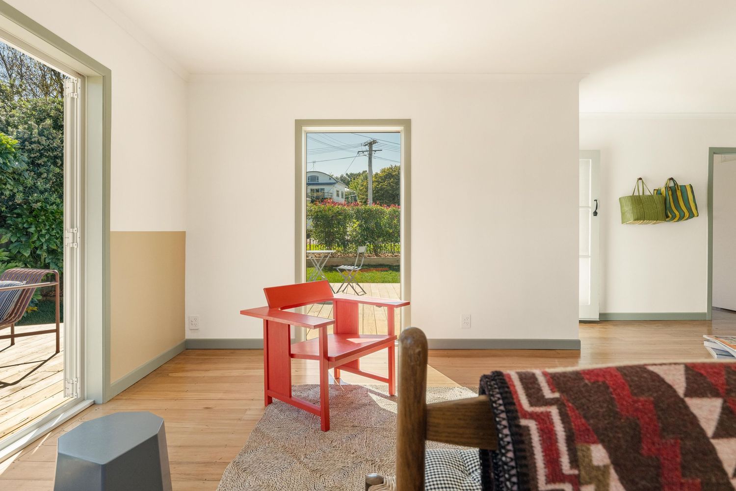 Modern apartment interior with bright white walls, hardwood floors, and multiple windows providing natural light.