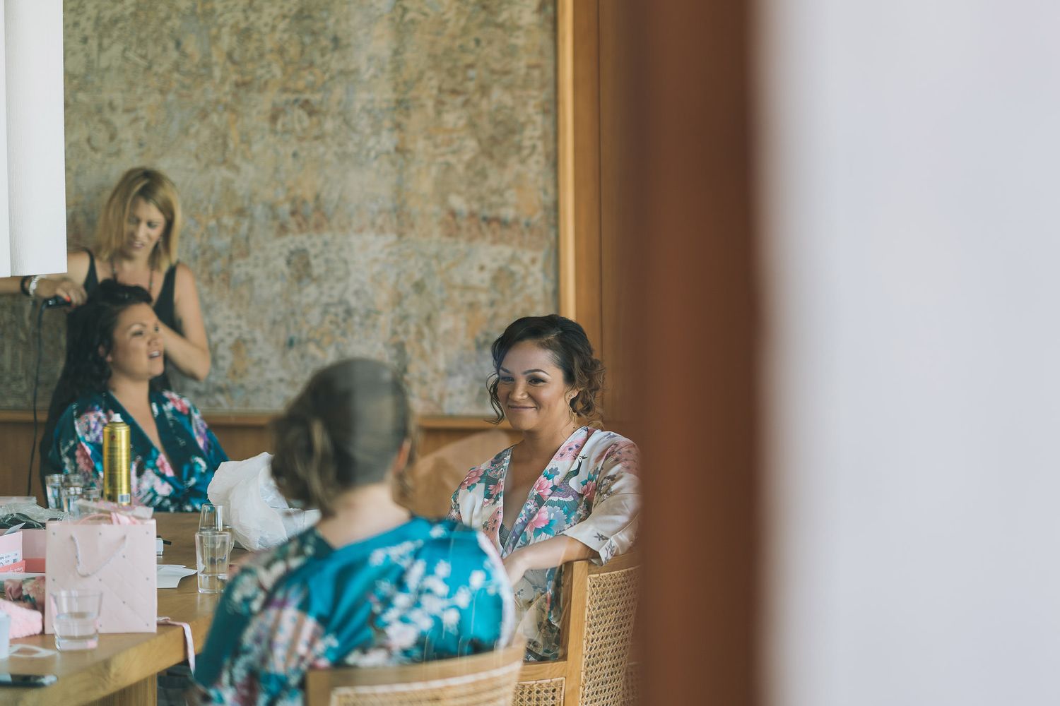 People gathered around dining tables in a casual indoor setting with rustic stone wall backdrop.