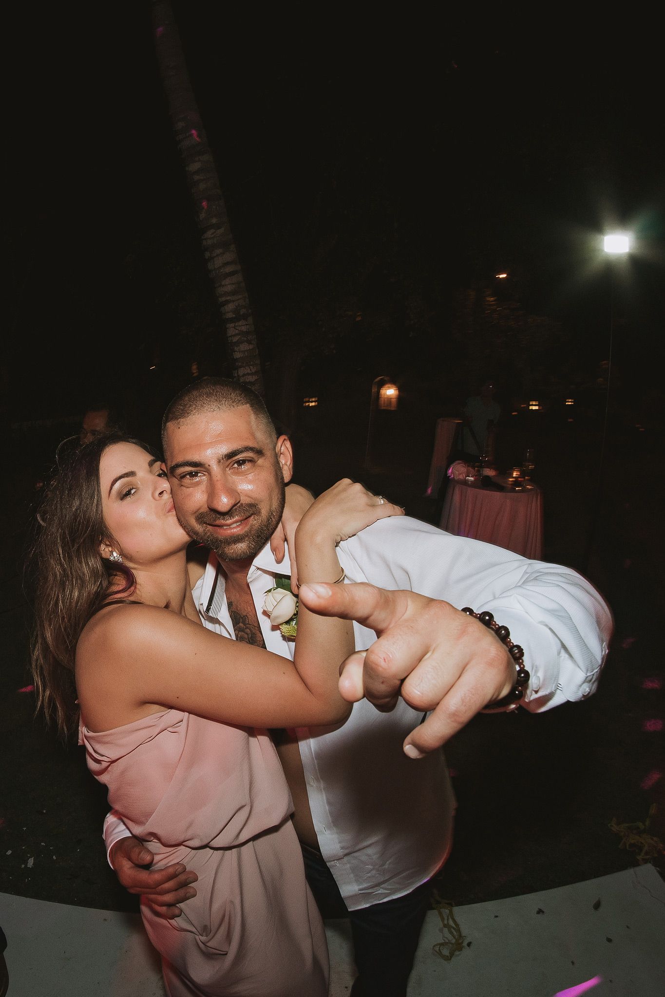 A couple dancing together at a nighttime outdoor reception.