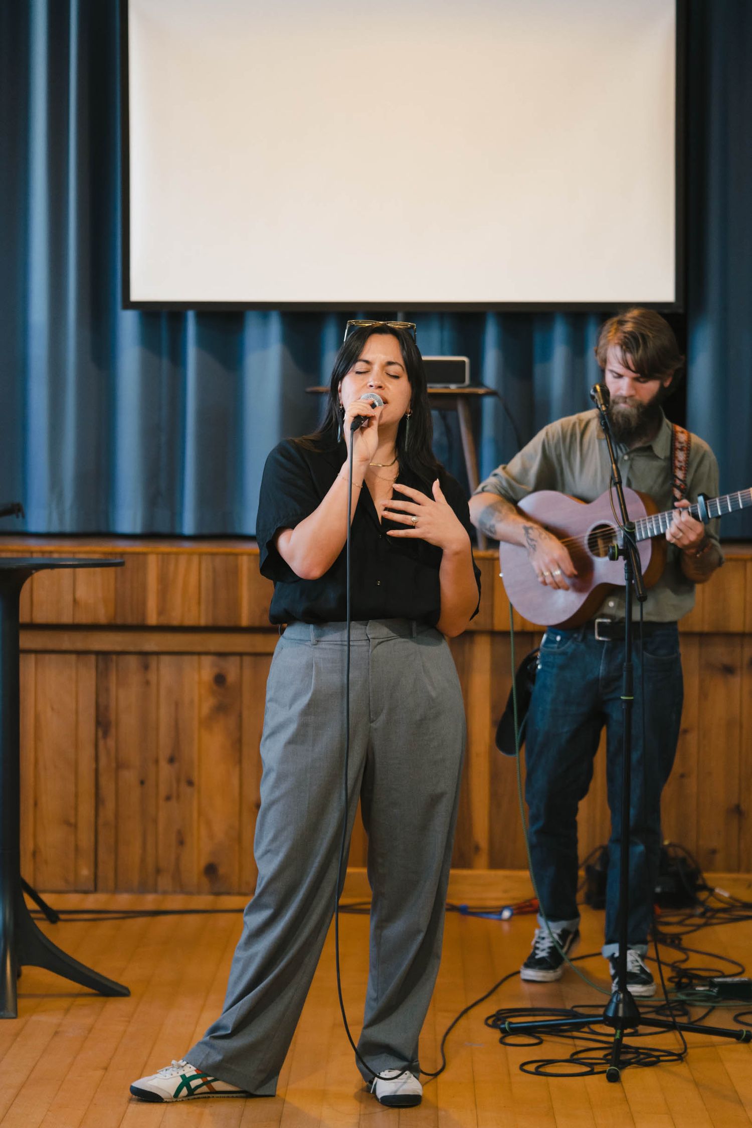 Musicians performing on stage with guitar and microphone setup.