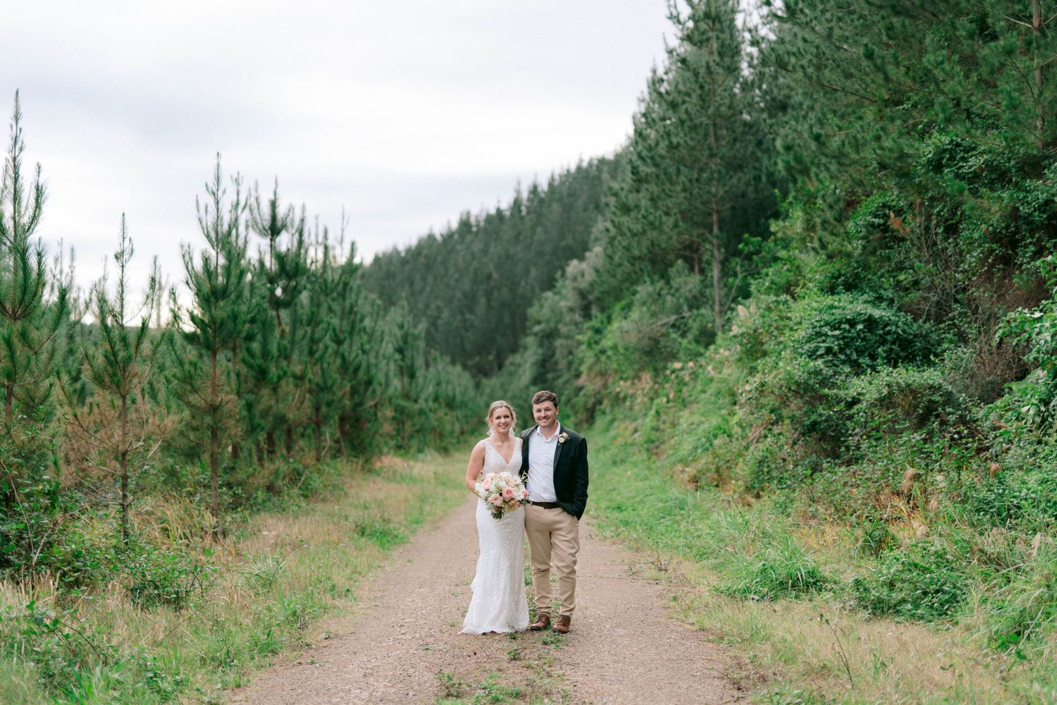 A dreamy walkway through lush green forest setting for an elegant outdoor wedding photography session.
