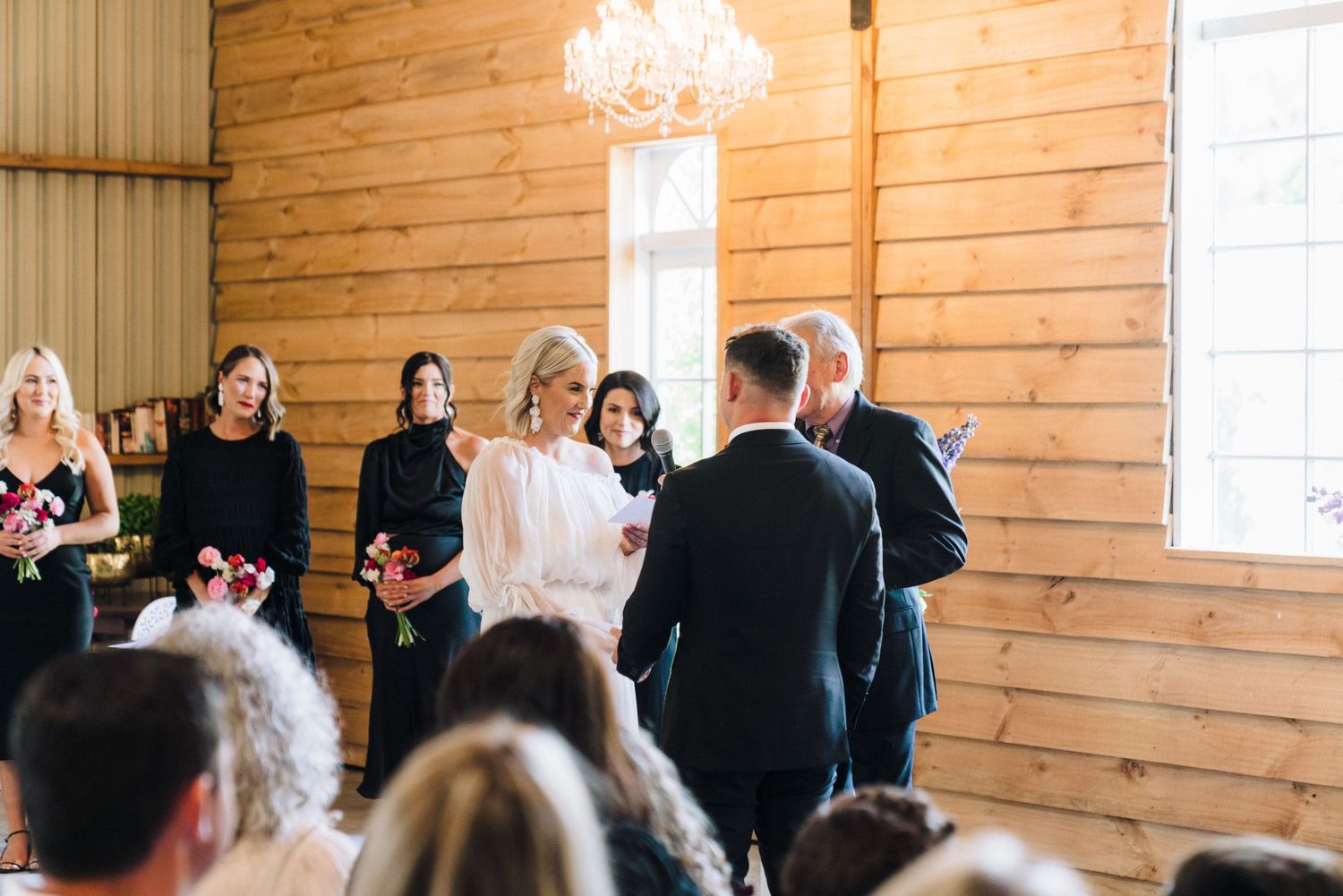 Wedding ceremony in progress inside a rustic wooden chapel with natural lighting.