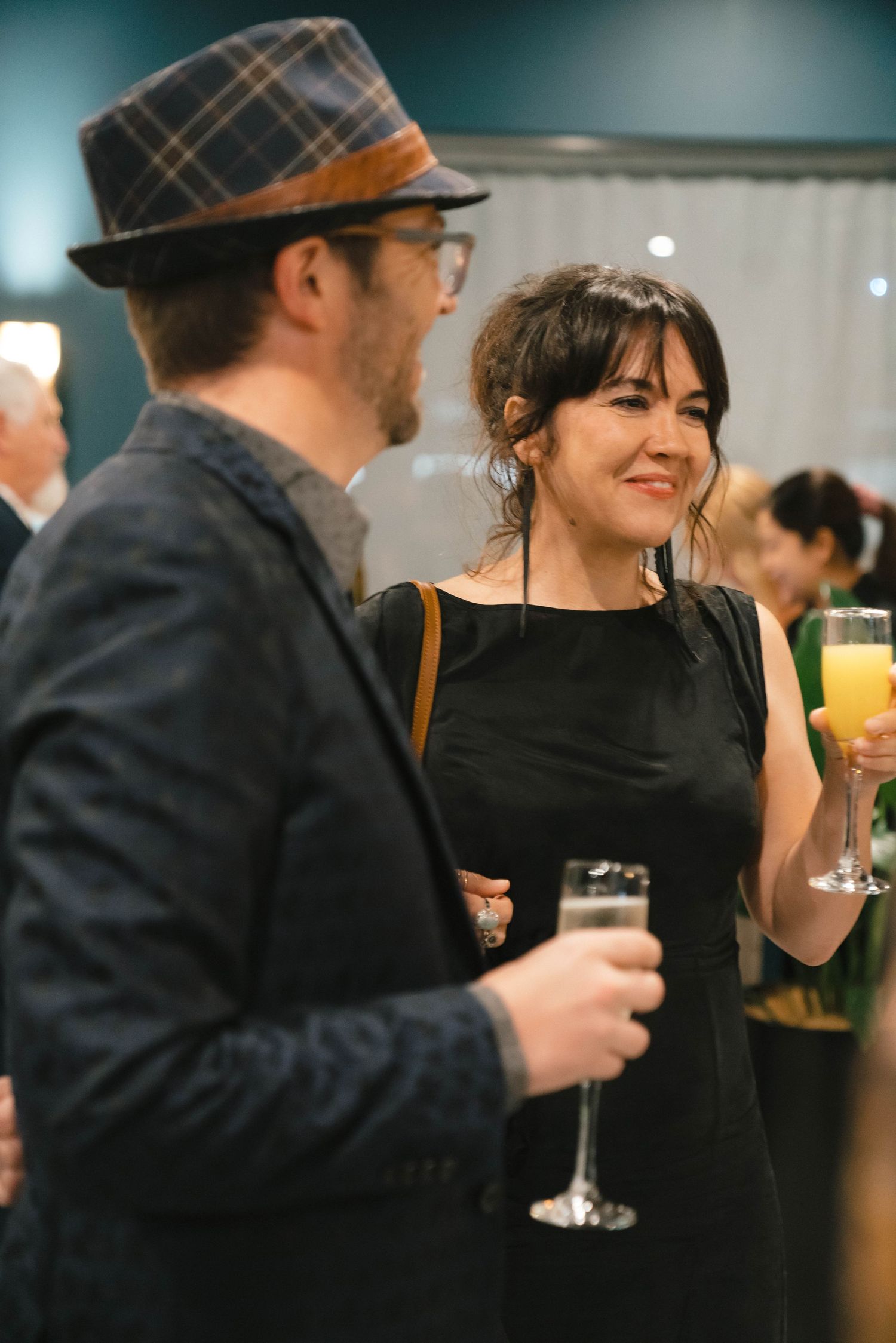 Two guests enjoying cocktails and conversation at an elegant evening event.