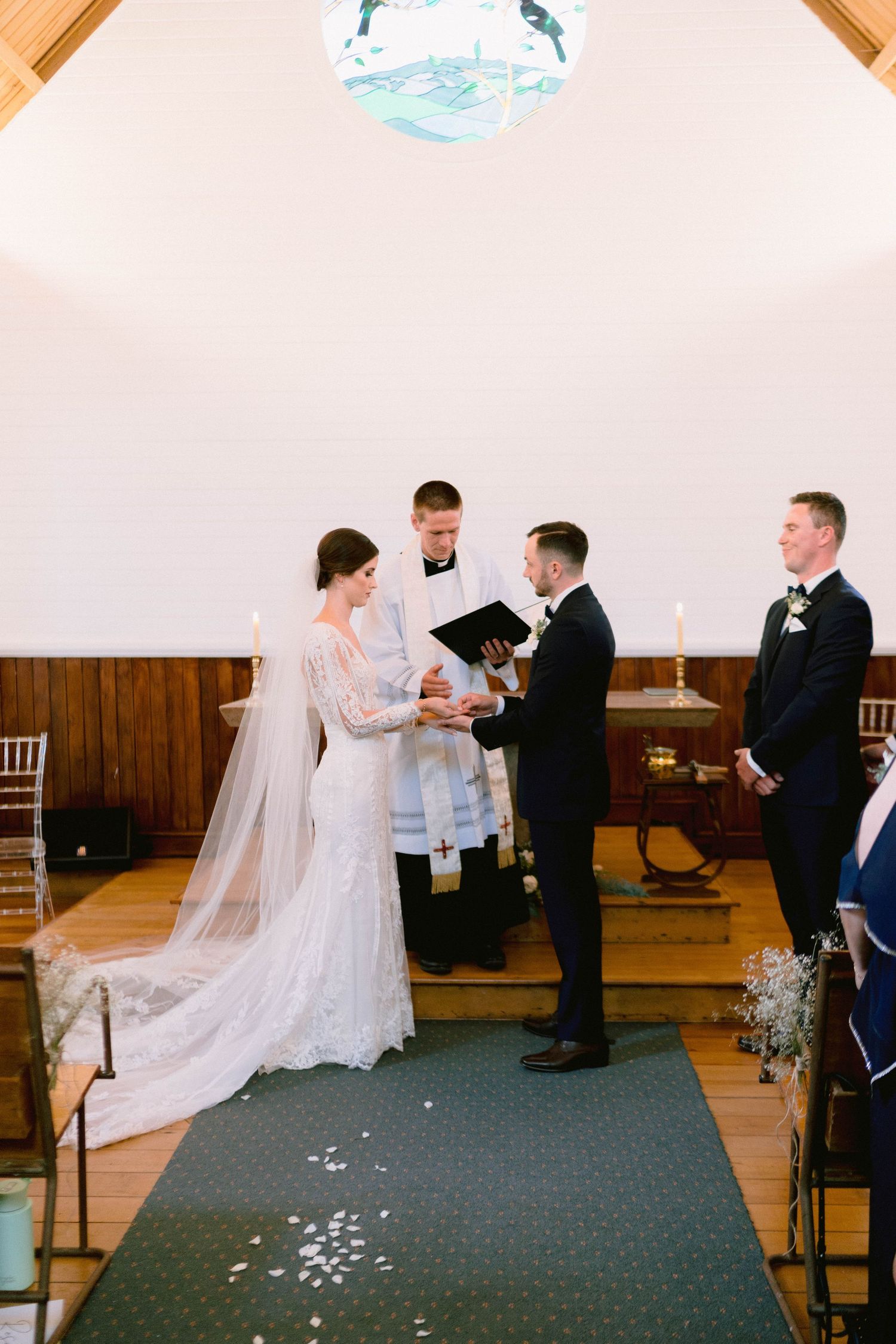 Traditional wedding ceremony taking place in a charming chapel with wooden interior.