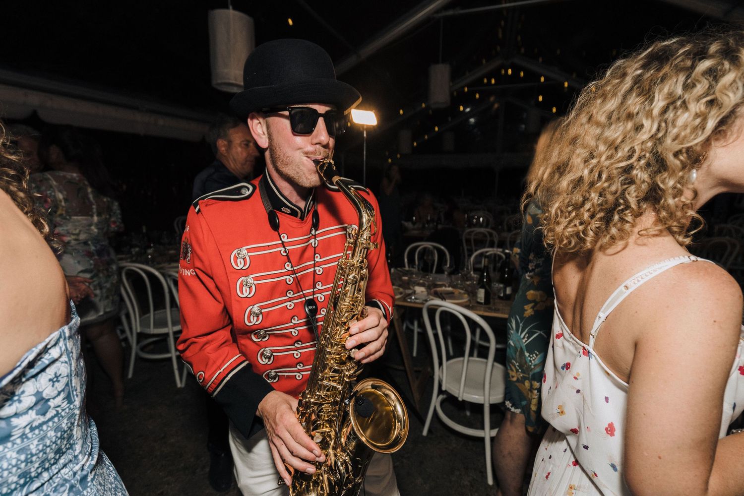 Wedding guests dancing and celebrating on the reception dance floor with vibrant energy.