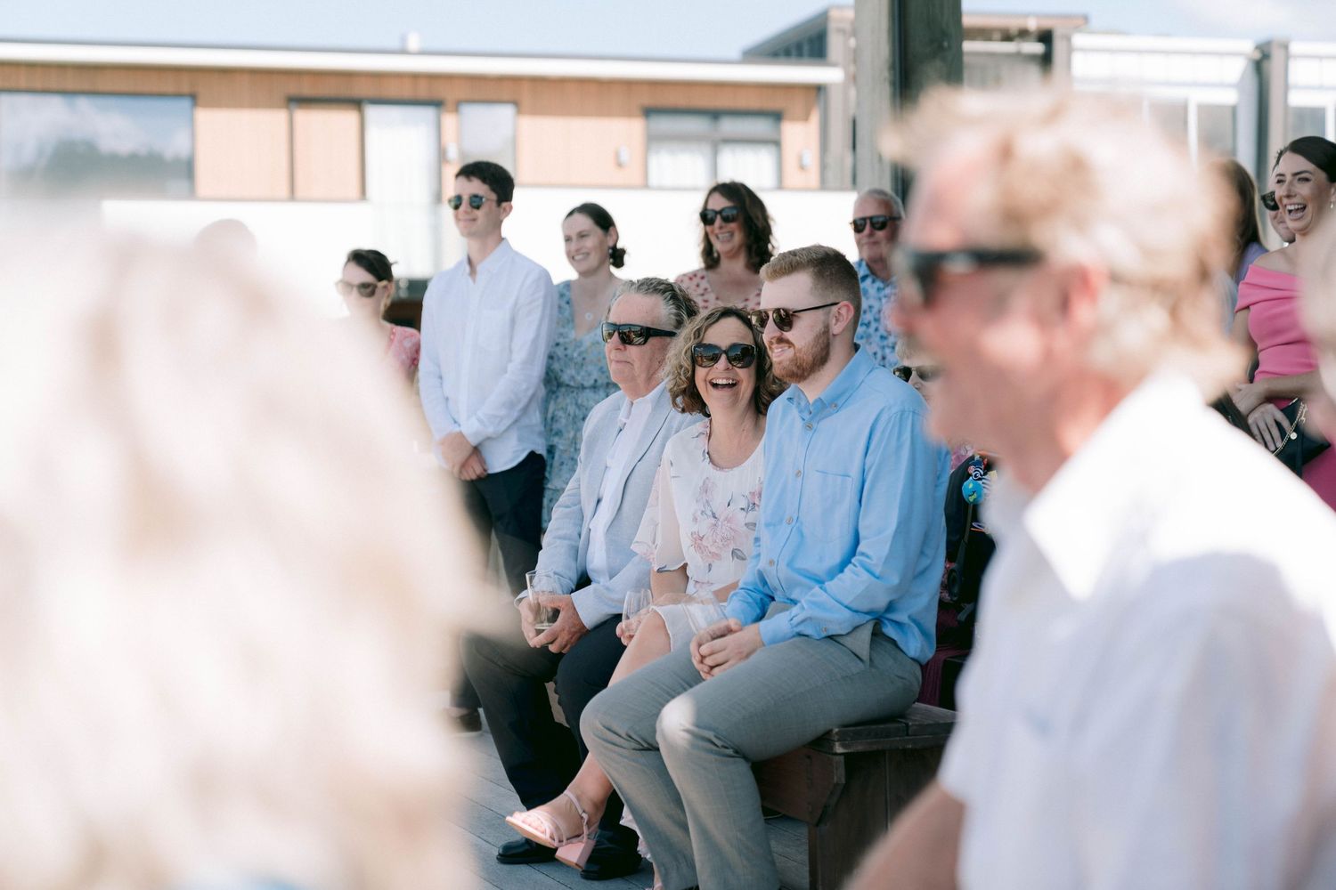 Wedding guests seated in rows at an outdoor ceremony venue with scenic views.