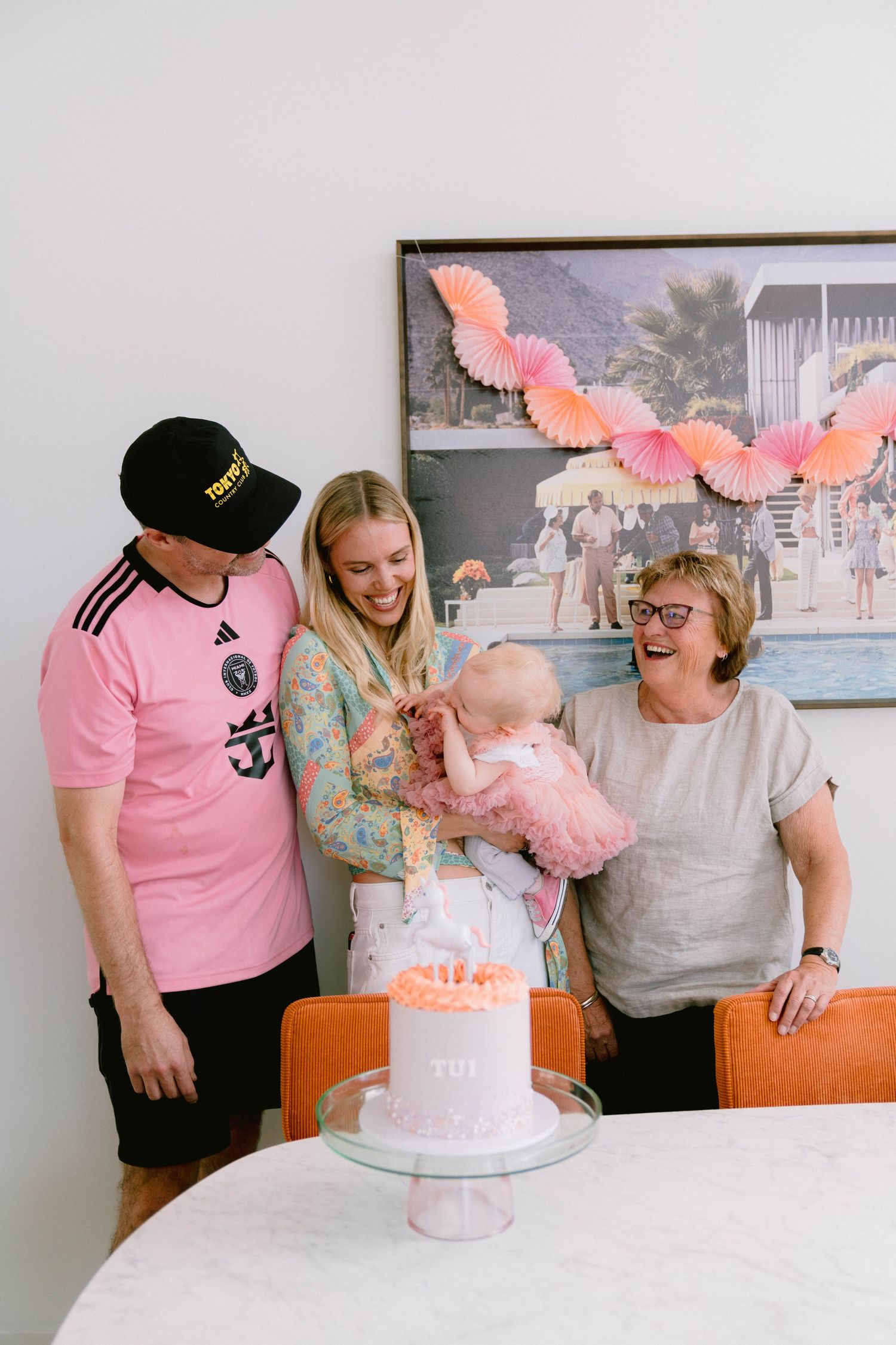 A pink and white birthday celebration scene shows a decorated table with butterfly decor and a white tiered cake.