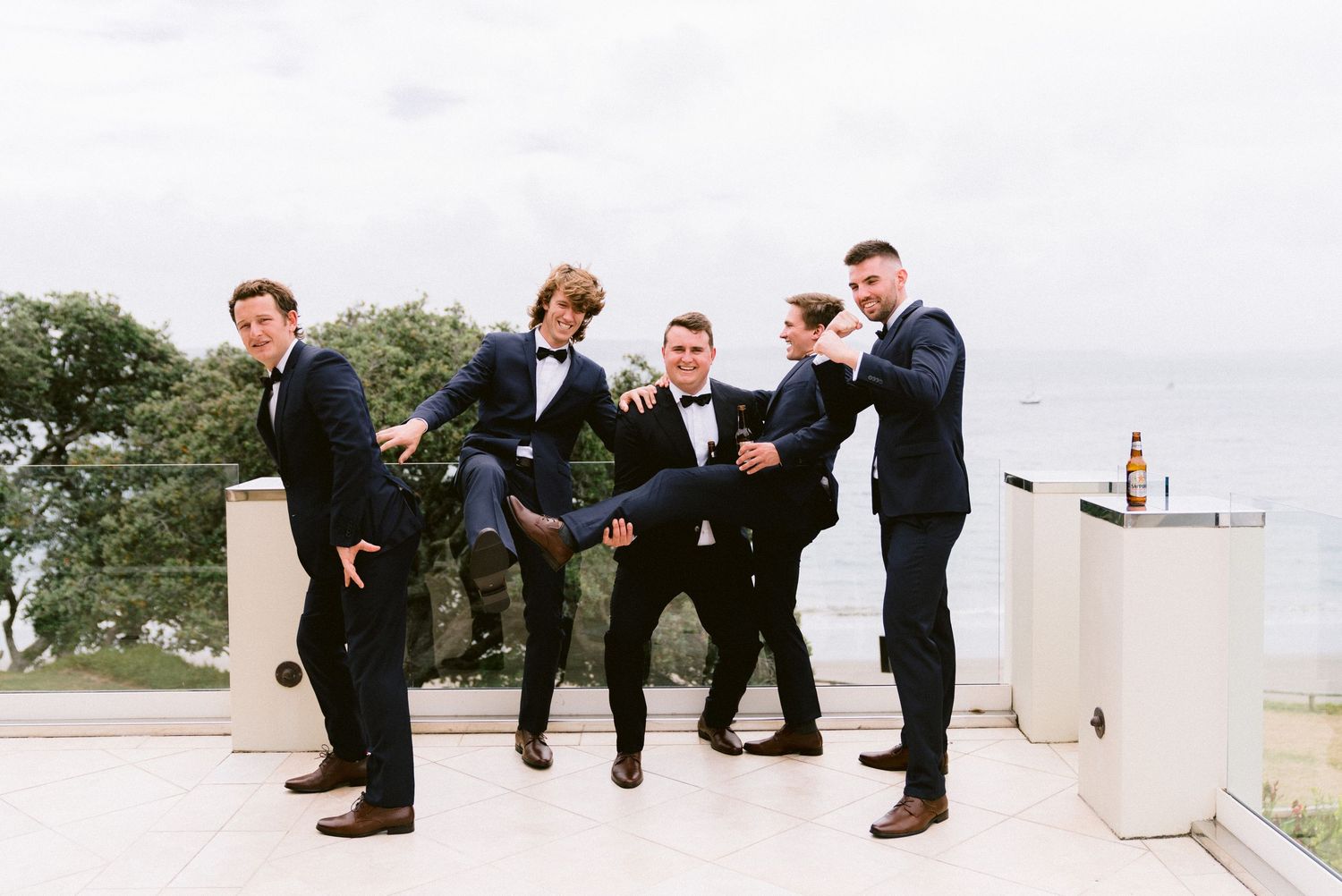 Groomsmen in black tuxedos show off their colorful socks in a fun group photo.