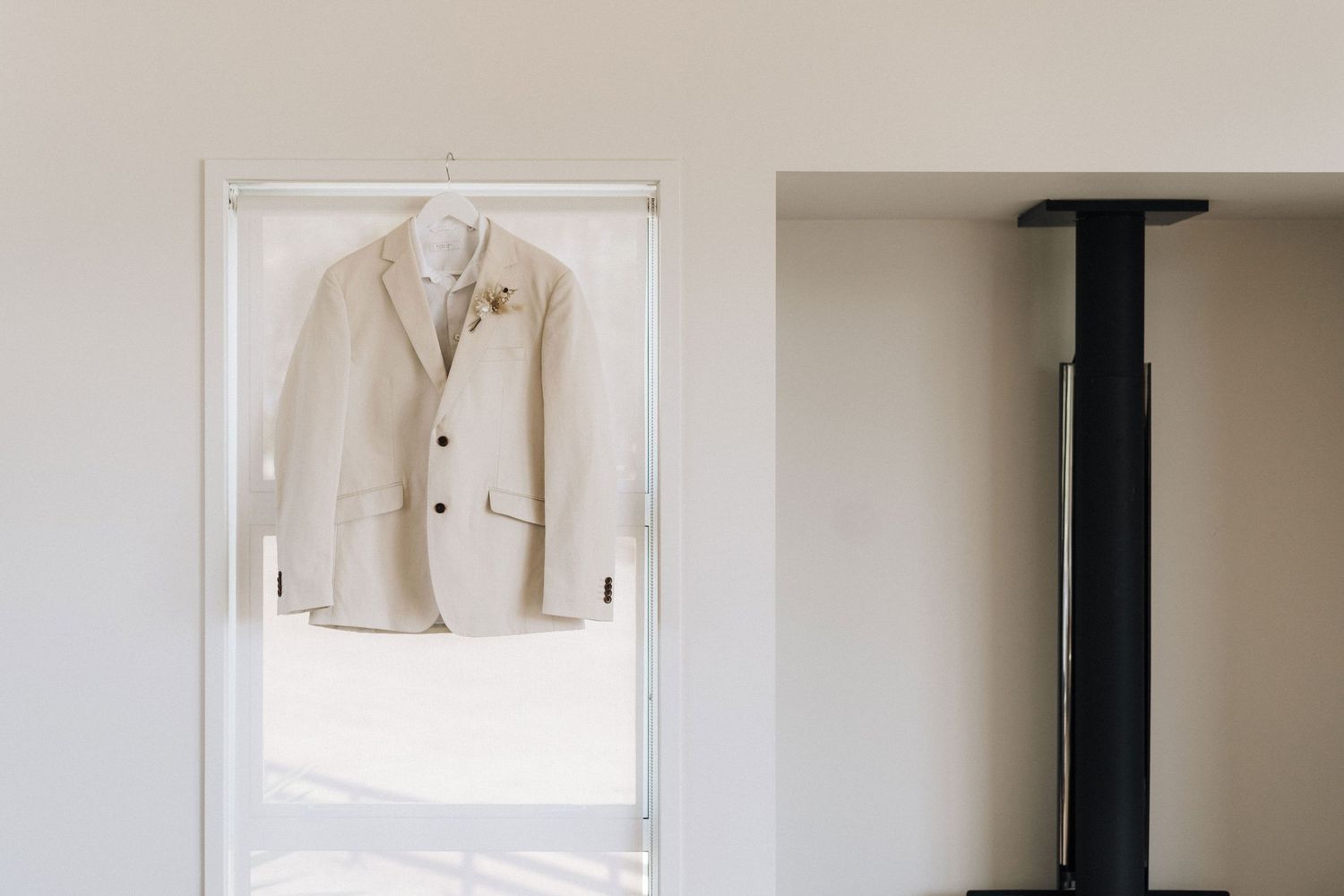 A series of dry cleaning hangers are mounted on a white wall displaying clean white garments.