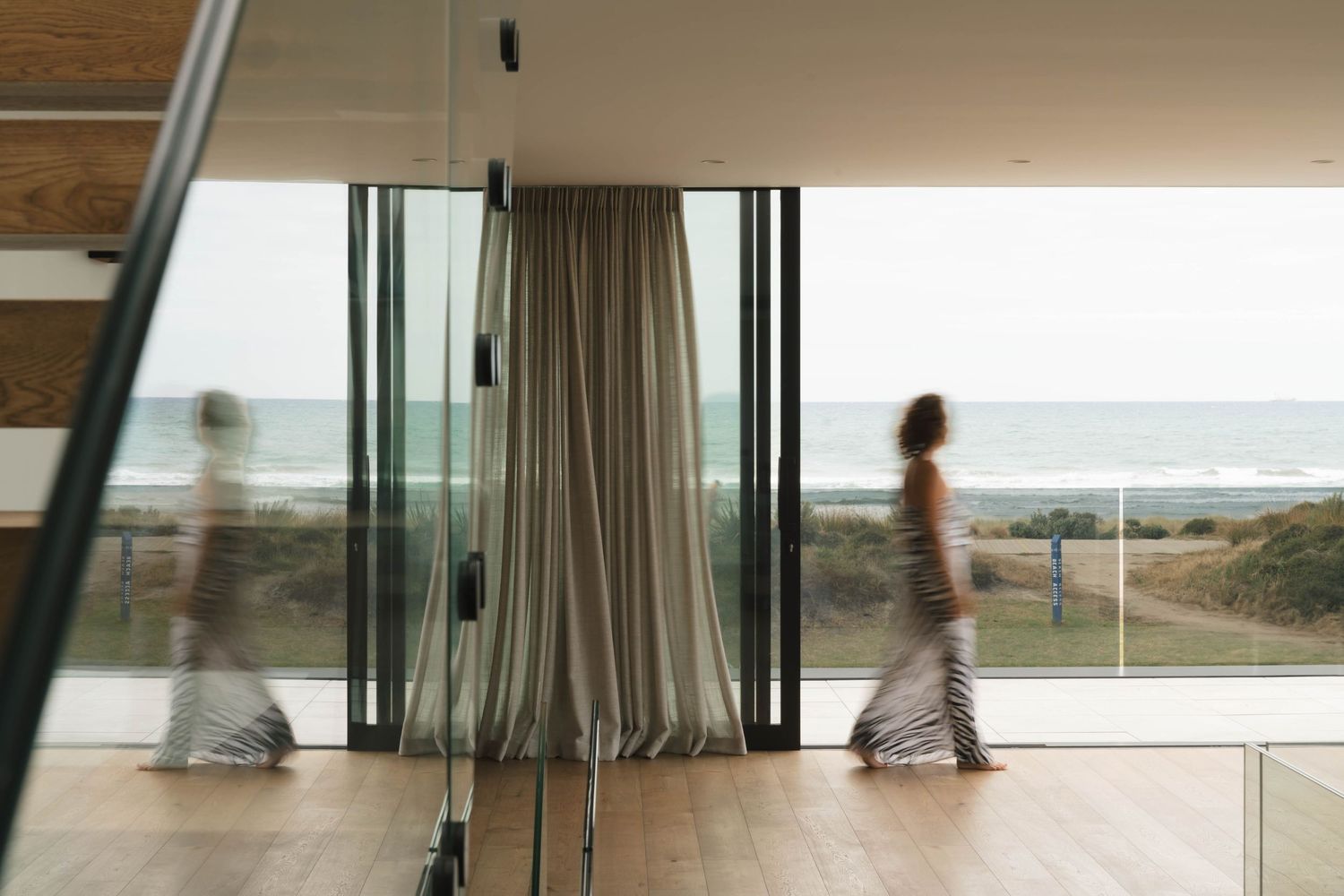 Interior corridor with glass walls revealing panoramic ocean views.