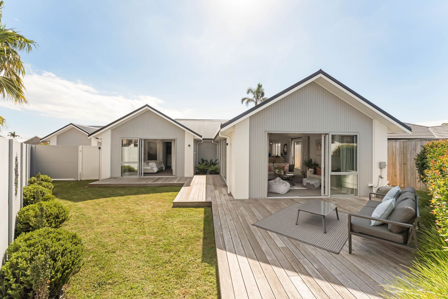Modern coastal home exterior featuring spacious deck and outdoor entertaining areas with ocean views.
