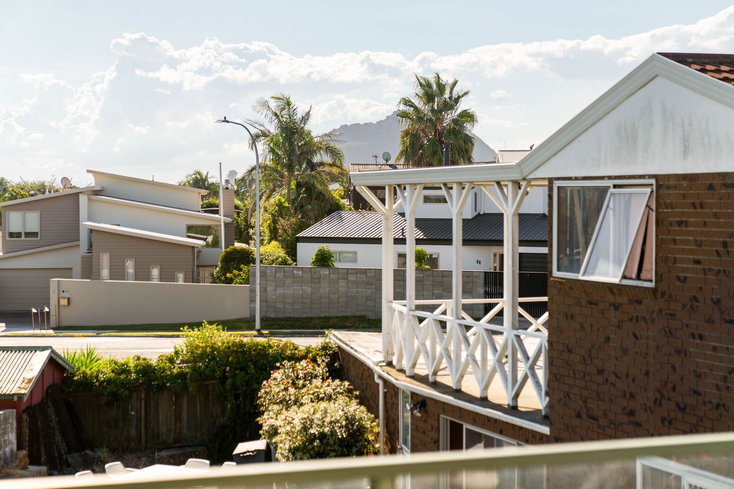 Aerial view of coastal mobile home park showing multiple residential units with palm trees and fencing along beachfront property.