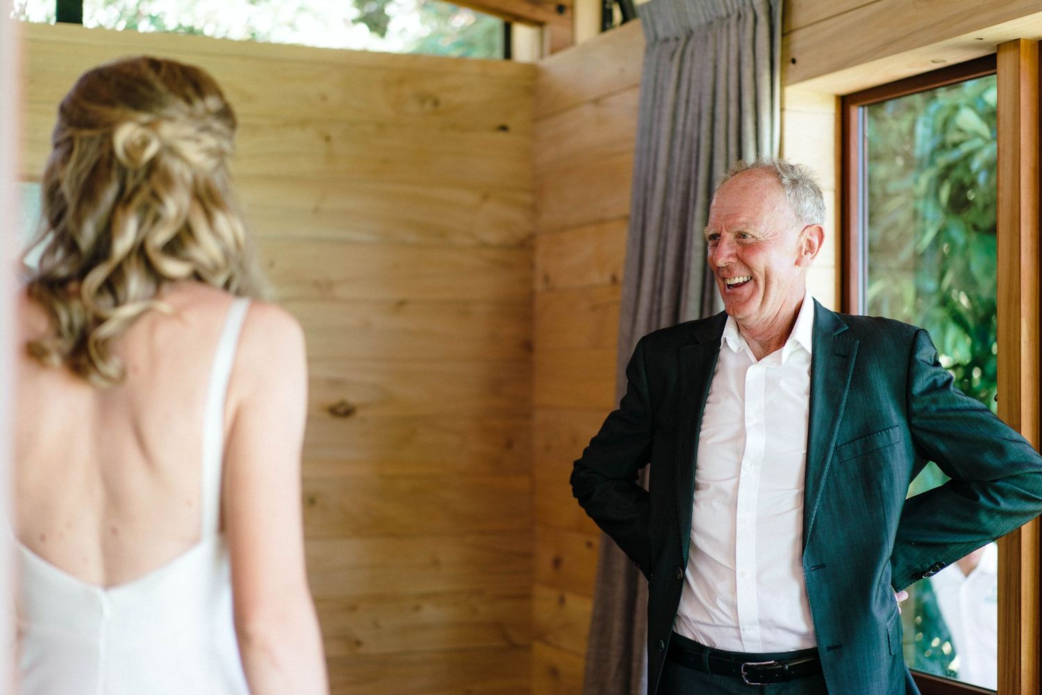 Light-filled room with rustic wooden walls during a formal event.