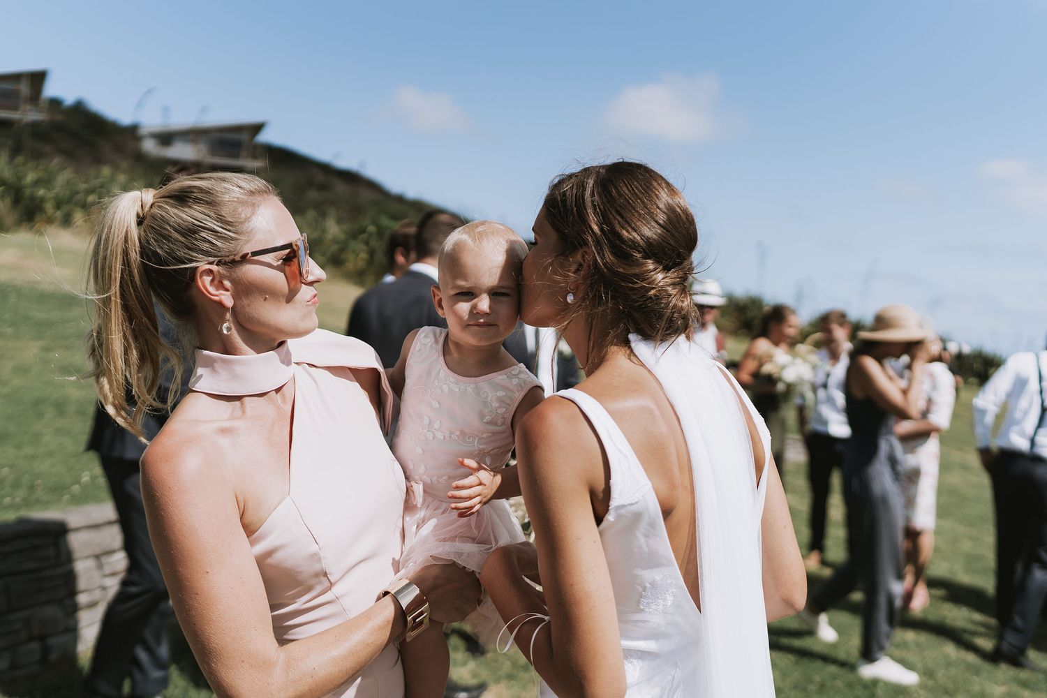 A group enjoys summer wine tasting at an outdoor vineyard event on a sunny day.
