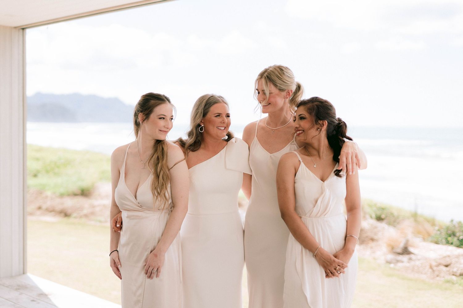 Wedding party poses together on scenic coastal cliffside for romantic outdoor celebration portraits.