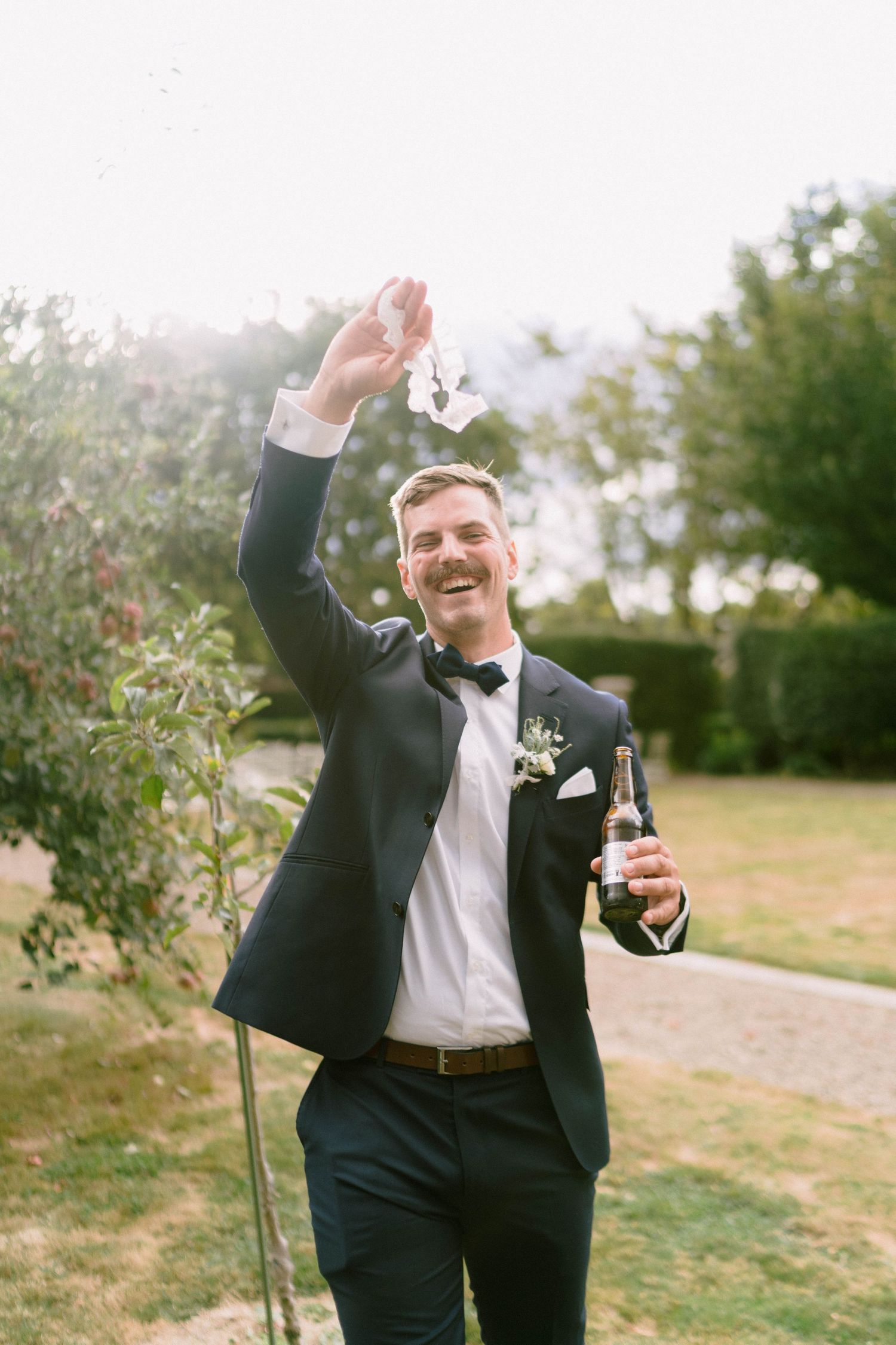 Joyful celebration with champagne and confetti on a sunny outdoor wedding day.