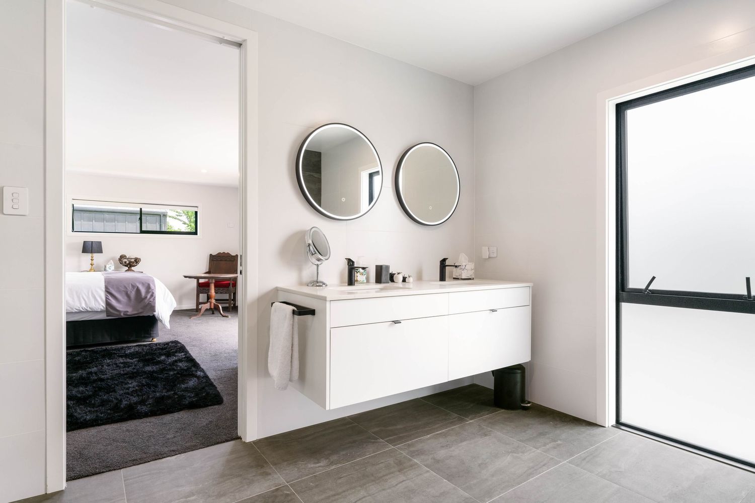 Clean modern bathroom design with white fixtures and black accent wall.
