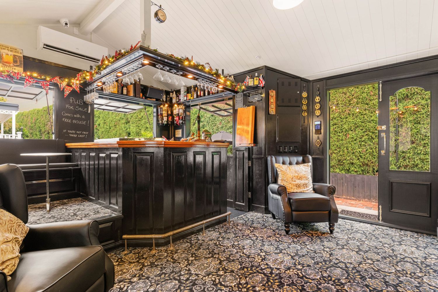 Entertainment room with dark wood paneling, bar area, and comfortable lounge seating.