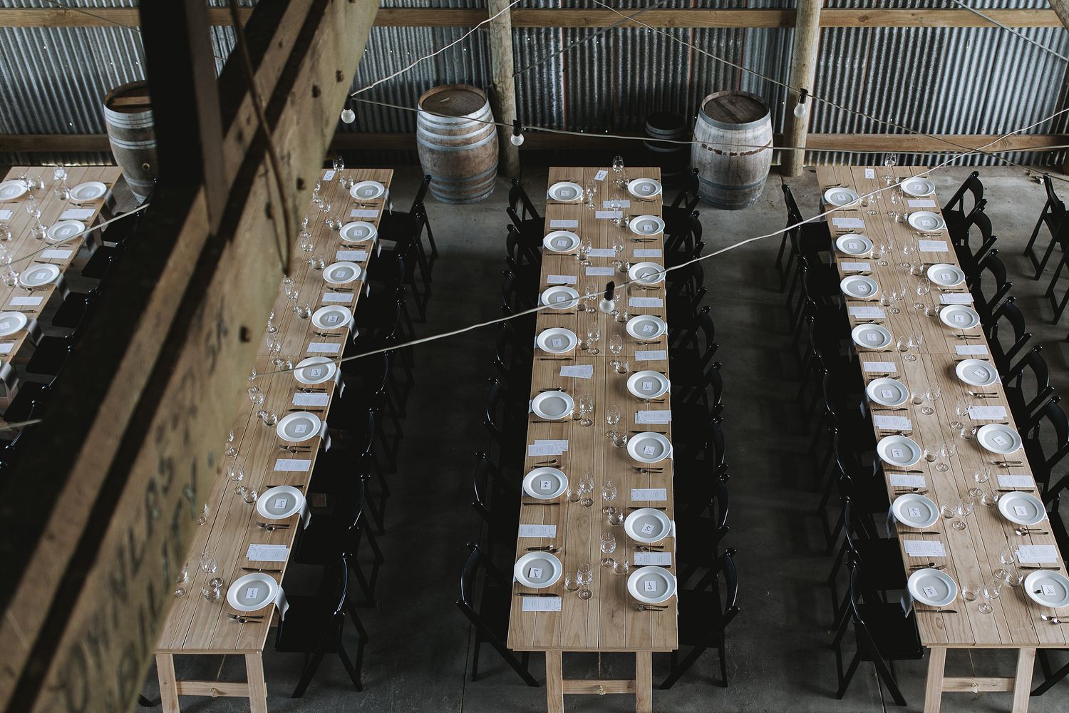 A long banquet table set with white tablecloths and wine glasses extends through an elegant dining room.