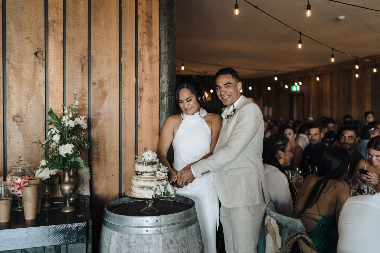 Rustic barn wedding reception with string lights creating a warm romantic atmosphere.
