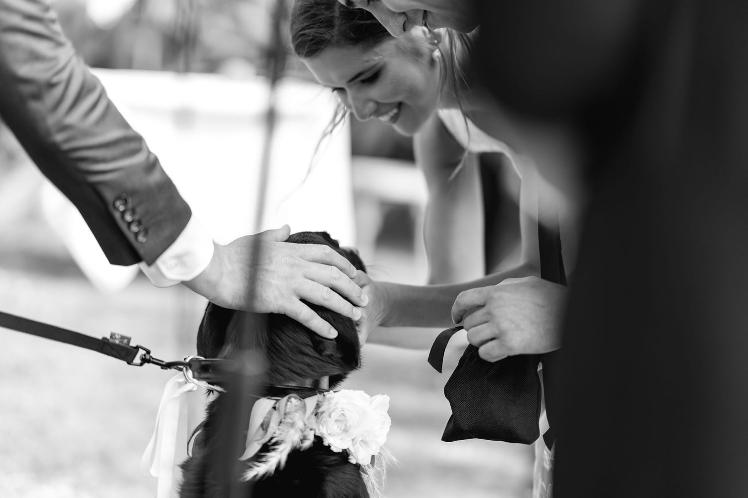 Someone pours champagne into a tower of glasses during a celebratory event in black and white.