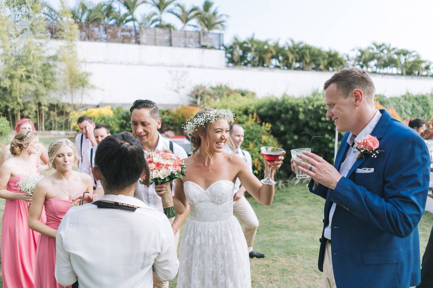 Wedding party celebrating outdoors with the newlyweds sharing a joyful moment.