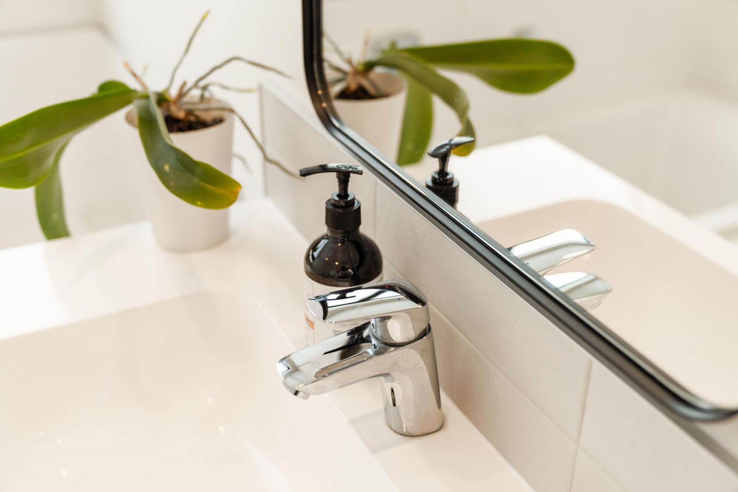Close-up of chrome bathroom faucet with sleek modern design against white background.