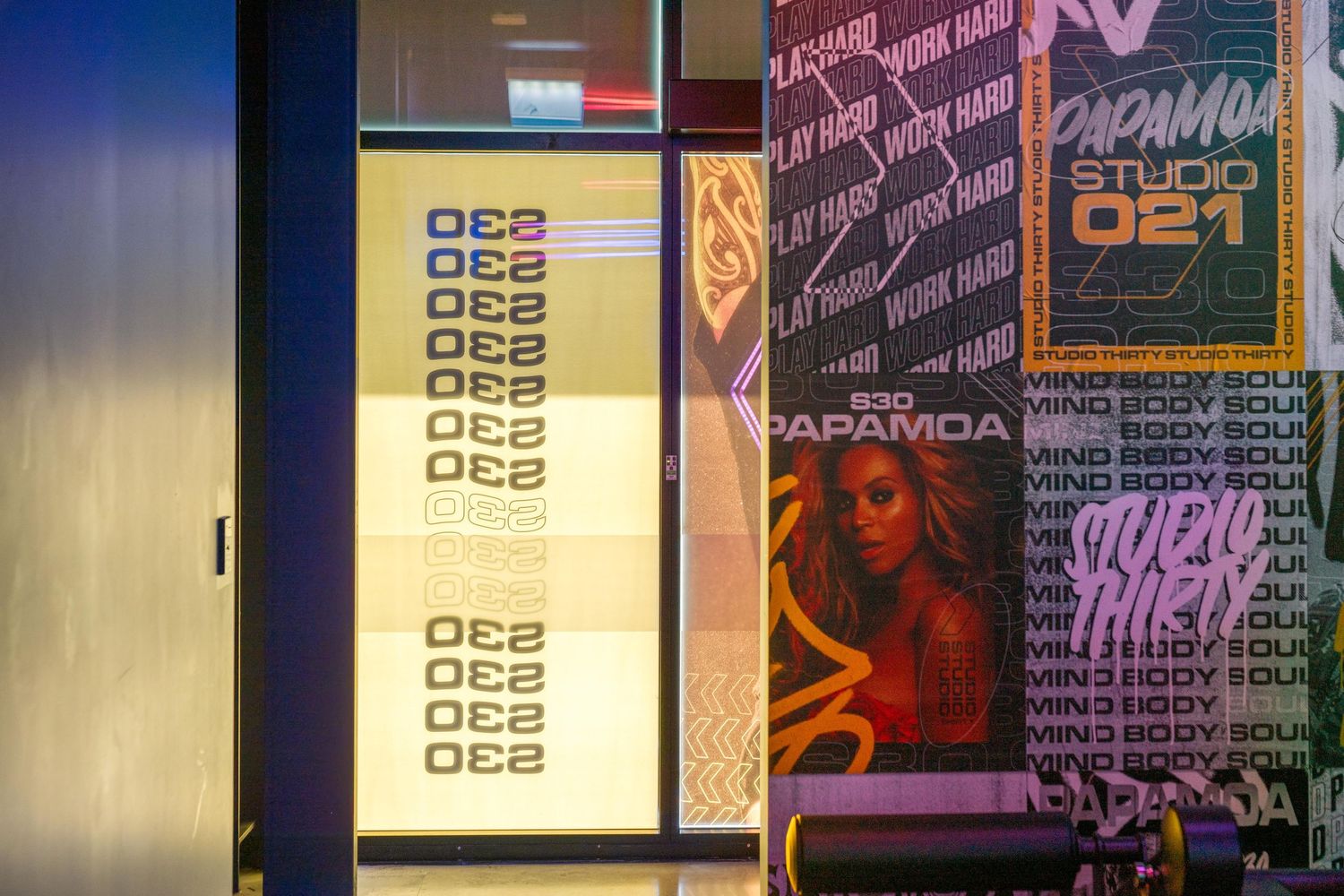 Digital display board with QR codes alongside colorful neon signage and posters.