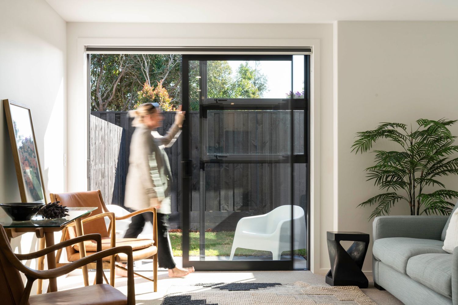 Contemporary living space with sliding glass doors opening to a backyard patio.