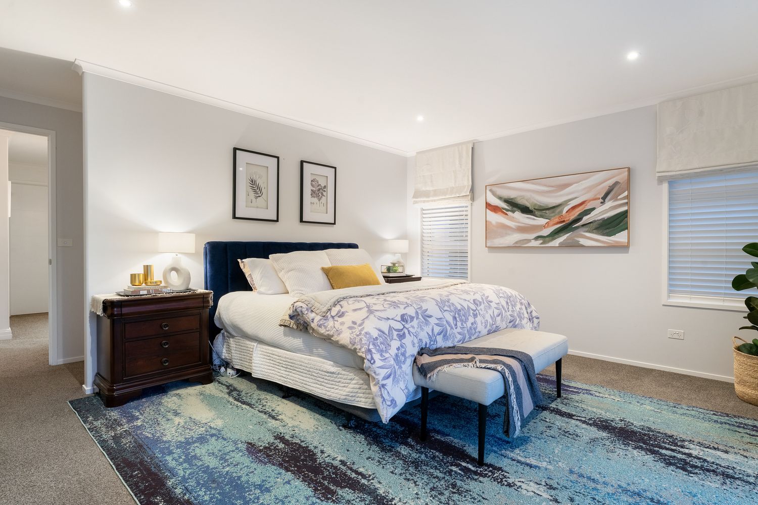 Bright living room showcases modern furnishings, wall art, and plush area rug in a contemporary setting.