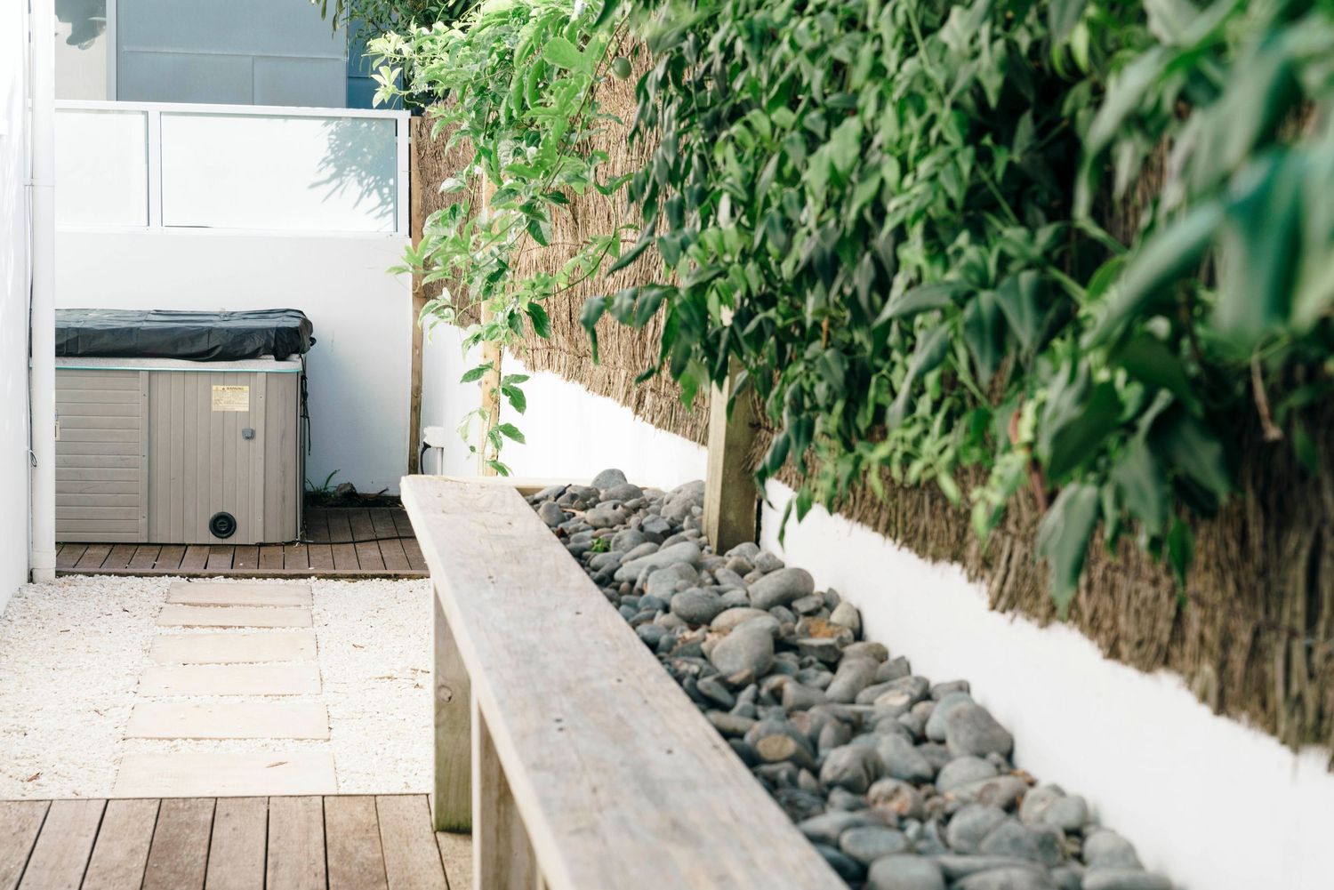 Outdoor patio space with wooden decking and decorative rock garden features.