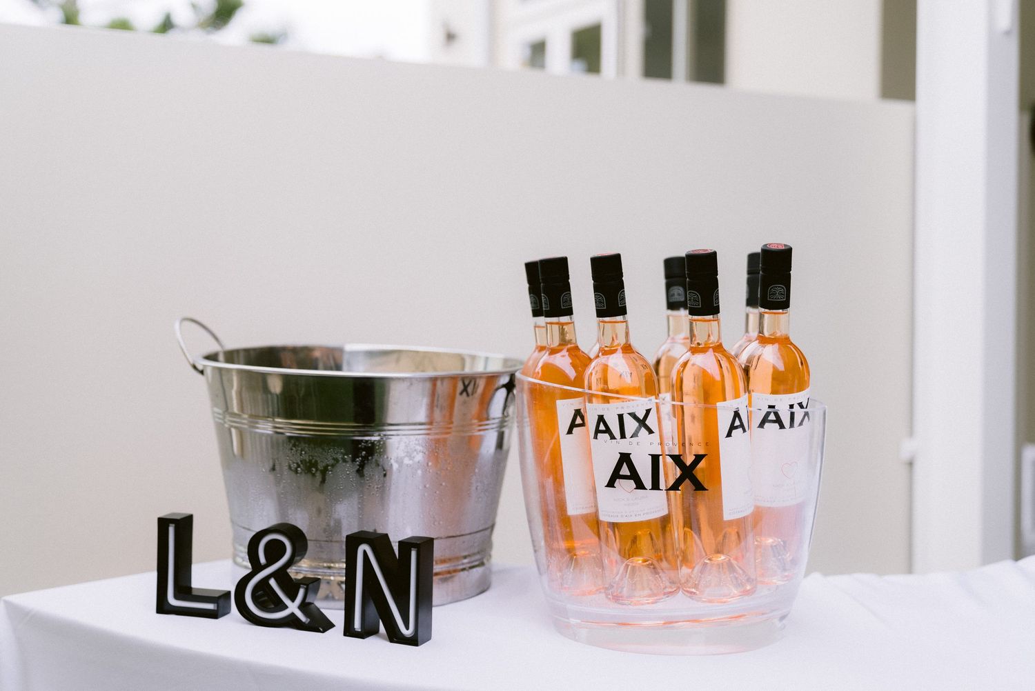 Wedding reception details featuring monogrammed cocktail glasses and drinks on display.