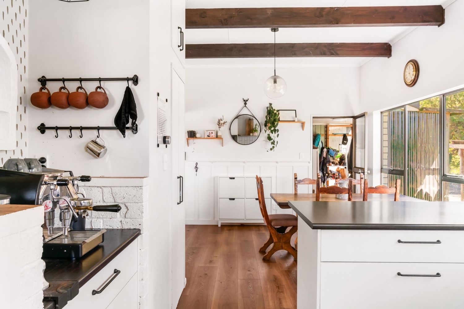 A modern kitchen design showcases floating shelves, white cabinets, and wood accents in a clean, minimalist style.