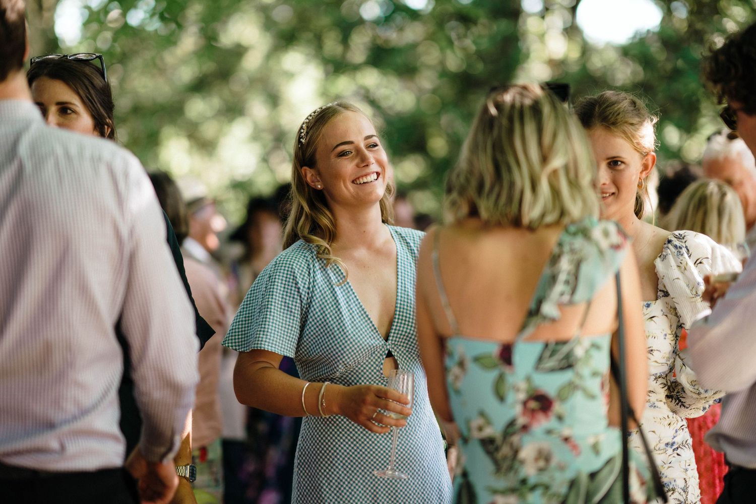 Candid moments of wedding guests enjoying conversation at an outdoor garden party.
