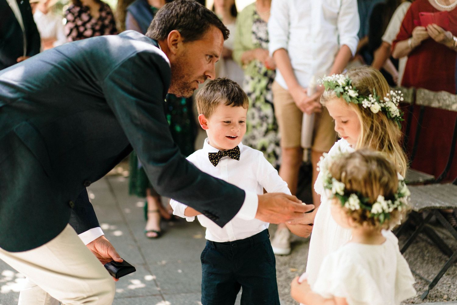 A joyful moment at a wedding celebration with children in formal attire playing and dancing outdoors.