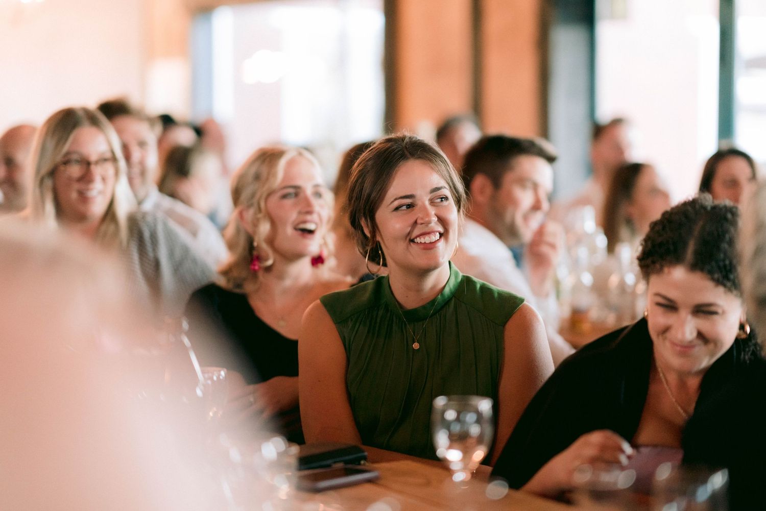 Wedding guests laughing and enjoying themselves during reception festivities.