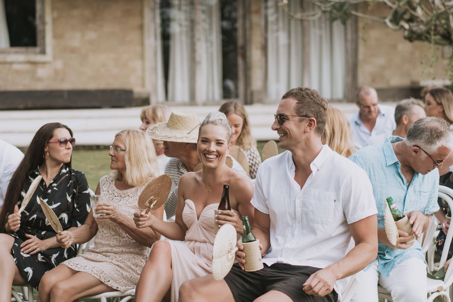 Wedding guests enjoying drinks and conversation at an outdoor celebration.