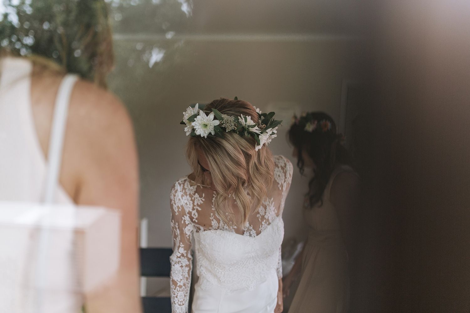 Elegant lace wedding dress details with delicate floral patterns and sheer fabric in soft natural lighting.