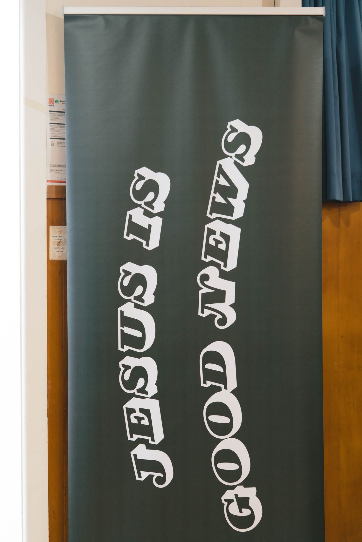 A chalkboard with white text reading 'Jesus is good news' written vertically in stylized letters.
