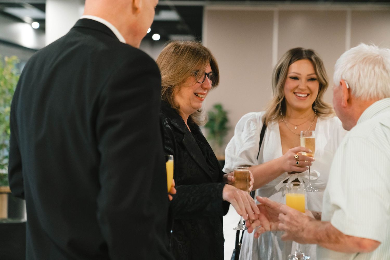 A group of people sharing drinks and laughing during a joyful celebration gathering.