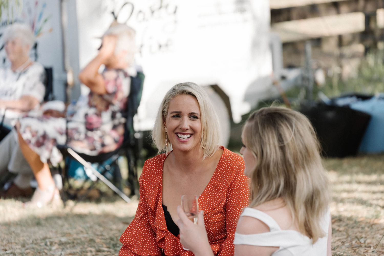 A group celebrates outdoors at a joyful casual gathering with natural lighting and festive atmosphere.