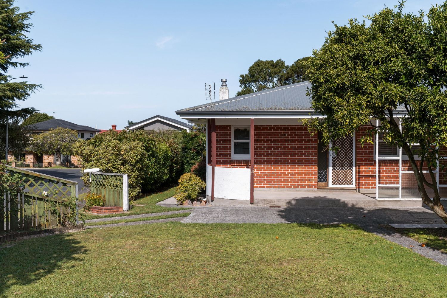 Red brick ranch house with extensive lawn and mountain views in rural setting.