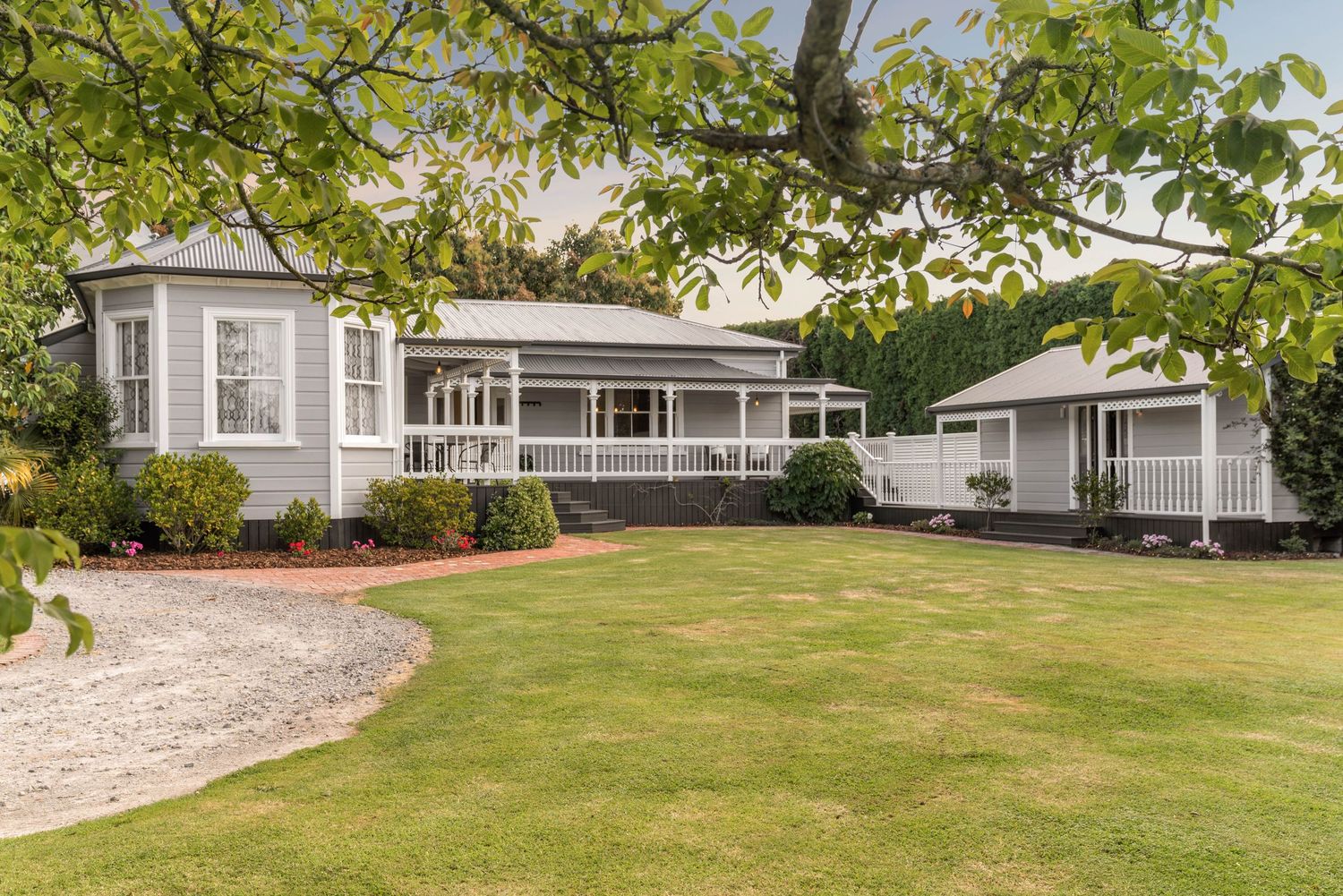 Well-maintained landscaping and lawn surrounding a modern residential property with classic architectural features.