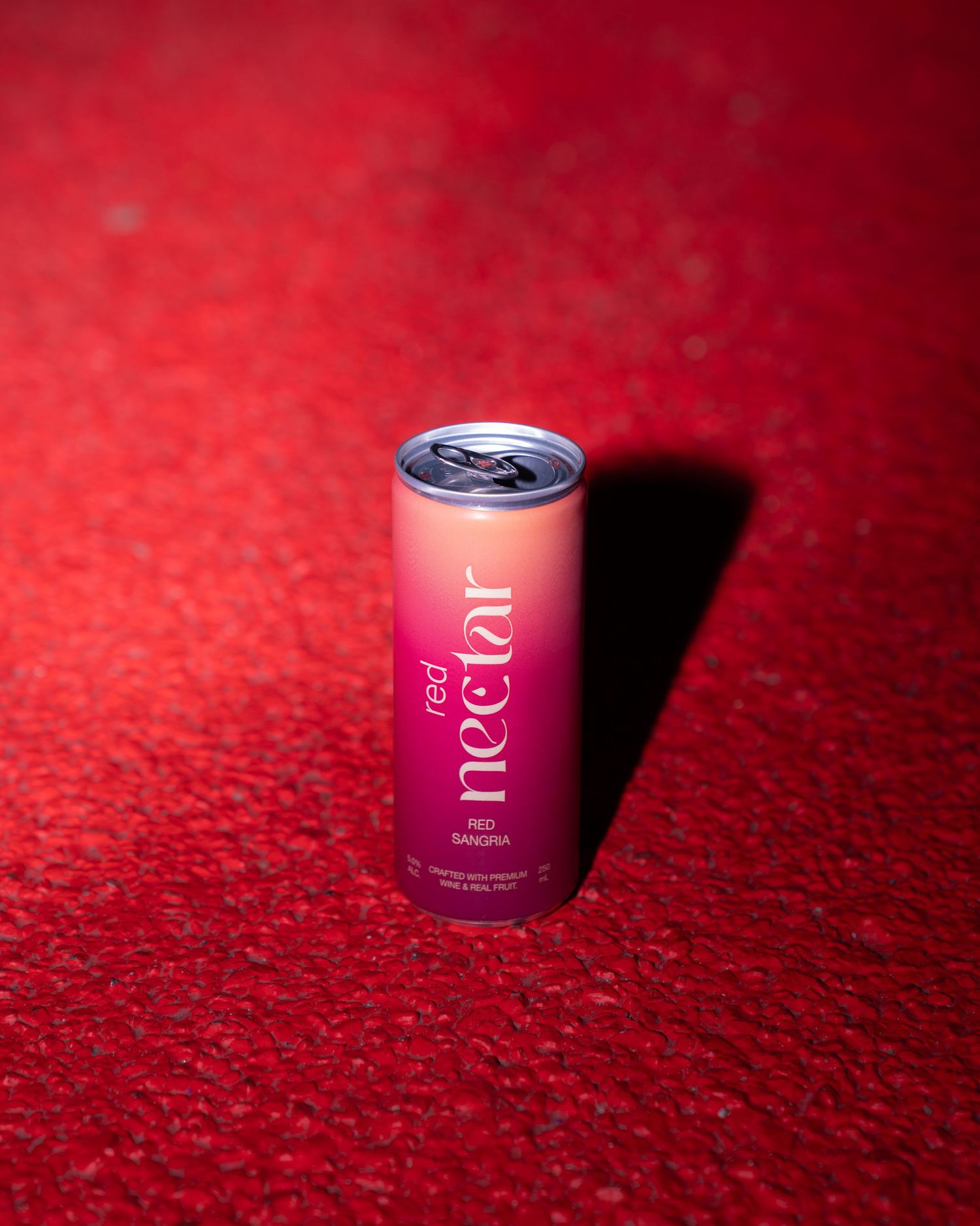 Pink skincare product jar on textured red background captured from multiple angles with dramatic shadows.